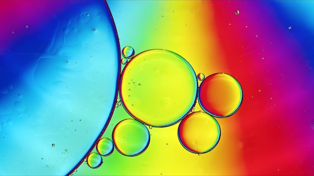 Abstrakcyjne kolorowe krople oleju spożywczego bąbelki i kulki przepływające na powierzchni wody Fotografia makro