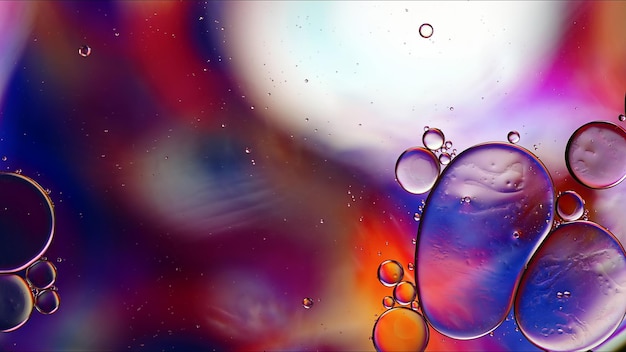 Abstrakcyjne kolorowe krople oleju spożywczego bąbelki i kulki przepływające na powierzchni wody Fotografia makro
