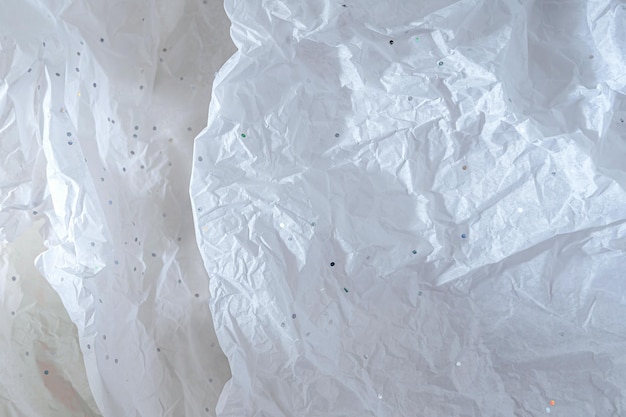 Abstrakcyjne tło z białym zmiętym papierem do pakowania z brokatem
