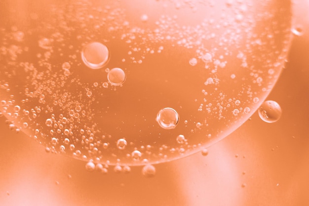Abstrakcyjny światło brzoskwinia Fuzz tło z krągami oleju pęcherzyki wody zbliżyć się pękerzyki oleju w wodzie makro krąg pęcherzyski tło Kolor roku 2024