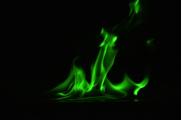 Abstrakta zieleni ogień płonie na czarnym tle