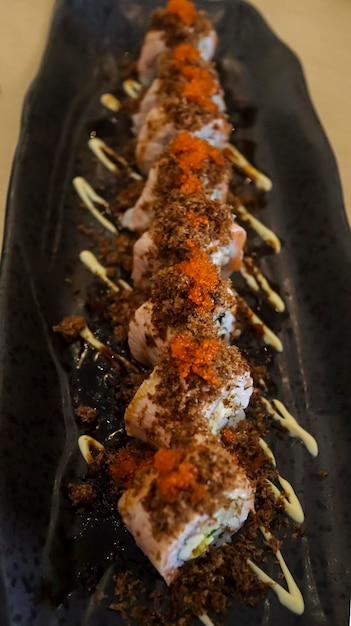 Zdjęcie aburi salmon roll składa się z mięsa kraba z ryżem sushi z kraba w miękkiej skorupce i zrolowanym następnie na wierzch podaje się aburi, czyli grillowane mięso rybne, które pochodzi z połączenia łososia i tuńczyka