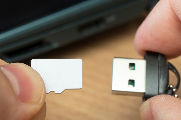 Adapter pamięci flash usb połączenie karty micro sd z kartą micro sd laptopa w dłoni mężczyzny