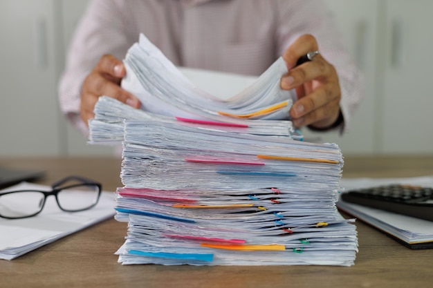 Administracja biznesowa i dokumenty z danymi na biurku Stos przeciążonego papieru biznesowego