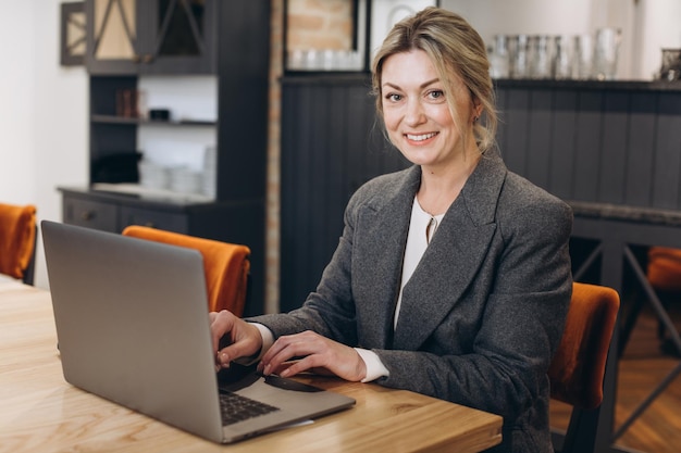 Administrator restauracji dojrzała kobieta biznesu siedzi i pracuje na laptopie