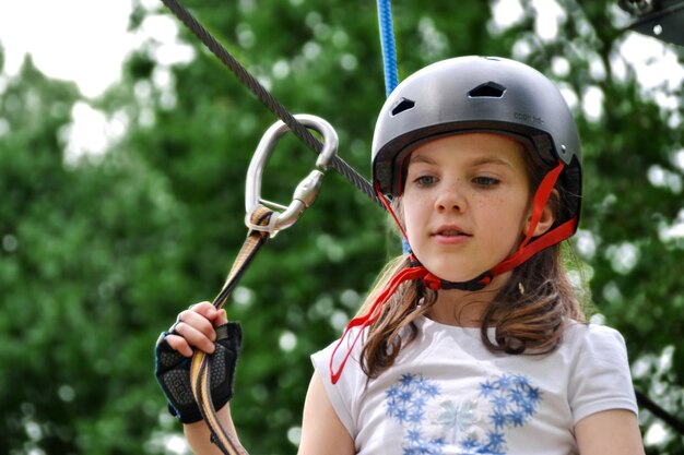 Zdjęcie adventure climbing high wire park - ludzie na kursie w kaskach górskich i sprzęcie bezpieczeństwa