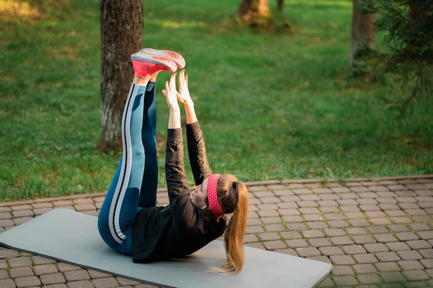 Aerobik fitness sport kobieta lekkoatletka trener robi ćwiczenia brzucha leżąc na macie