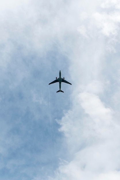 Zdjęcie aeroplano en el cielo azul con nubes desde abajo avion de pasajeros de alto vuelo