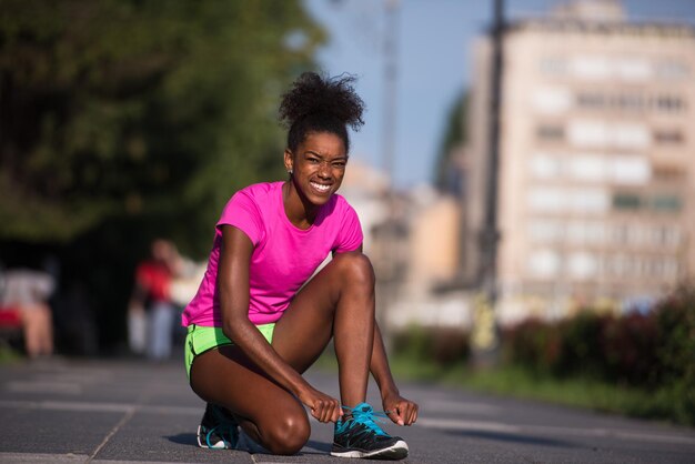 African american kobieta biegacz dokręcania buta koronki - fitness, ludzie i zdrowy styl życia