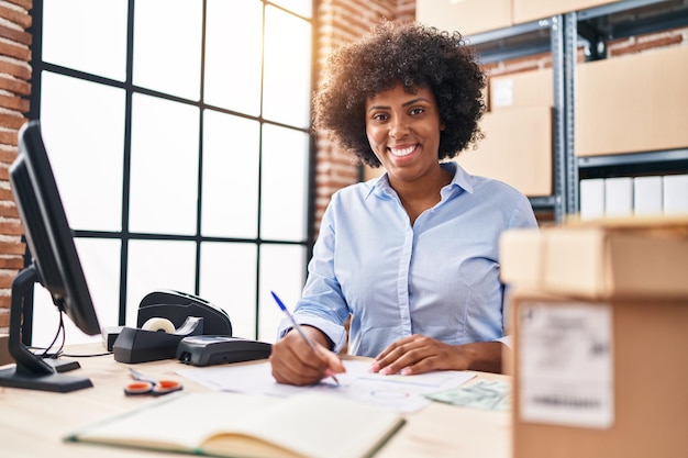 African american kobieta e-commerce biznes pracownik pisze na dokumencie w urzędzie