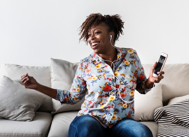 African American kobieta korzystających muzyki w domu wypoczynek i koncepcja muzyki