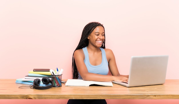 African American nastolatka student dziewczyna z długimi plecionymi włosami w swoim miejscu pracy