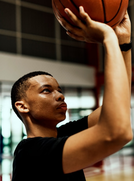 African American nastoletni chłopak koncentruje się na gry w koszykówkę