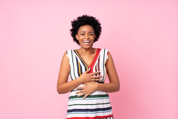 afro american kobieta śmiejąc się na białym tle na różowym tle