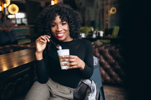 Afro amerykańska kobieta pije kawę w kawiarni