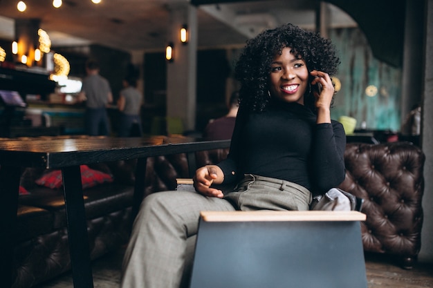 Afro amerykańska kobieta z telefonem w kawiarni