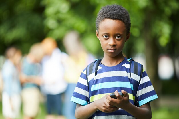 Afro-amerykański uczeń trzyma telefon