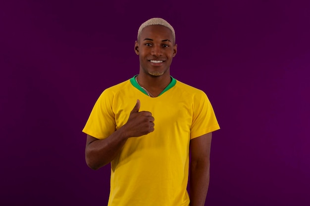 Afro brazylijski mężczyzna w koszulce drużyny piłkarskiej brasilia na puchar 2022 w Katarze