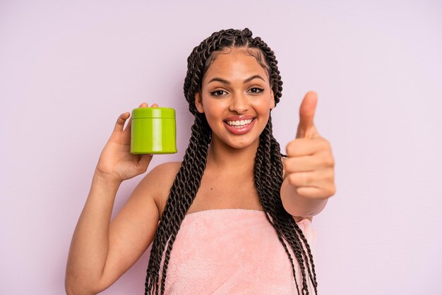 Afro czarna kobieta czuje się dumna, uśmiecha się pozytywnie z kciukami do góry. koncepcja leczenia włosów