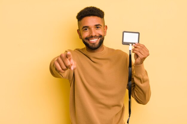 Afro fajny mężczyzna wskazujący na kamerę, wybierający ci koncepcję identyfikatora vip pass