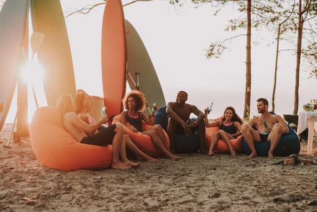 Afro Man odpoczywa z przyjaciółmi na plaży.