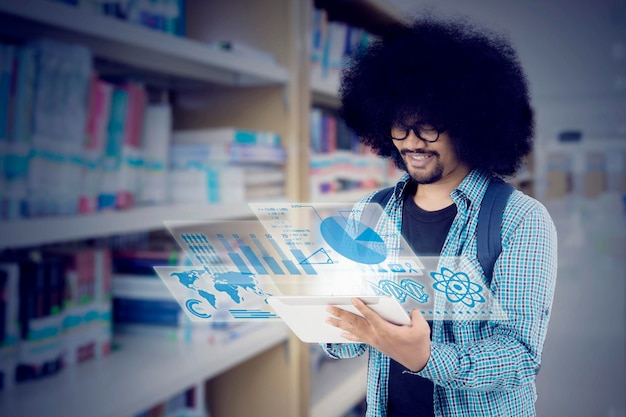 Afro student używający tabletu w bibliotece