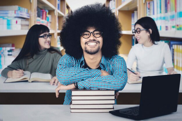 Afro student ze swoimi przyjaciółmi w bibliotece