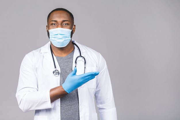 Afroamerykanin lekarz mężczyzna w rękawiczkach sterylnej maski medyczne fartuch. Palec wskazujący.