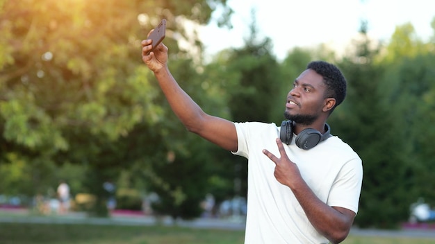 Afroamerykanin robi selfie na smartfonie w parku