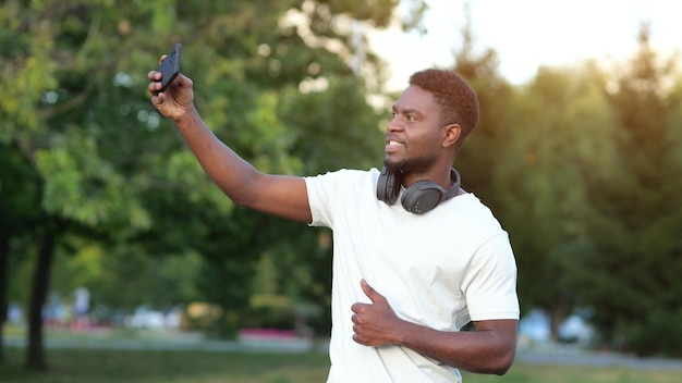 Afroamerykanin robi selfie na smartfonie w parku