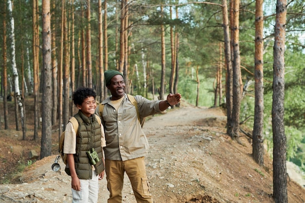 Afroamerykanin tata podróżuje z synem, spacerując po lesie