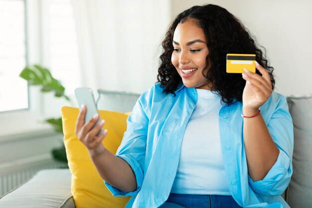 Afroamerykanka Korzystająca Z Telefonu I Karty Kredytowej Zakupy W Pomieszczeniach