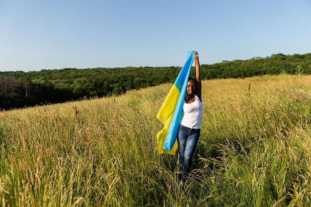 Afroamerykanka owinięta w ukraińską żółtą niebieską flagę narodowy symbol Ukrainy