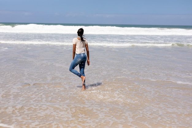 Afroamerykanka spacerująca po plaży nad morzem. zdrowy styl życia, wypoczynek na łonie natury.