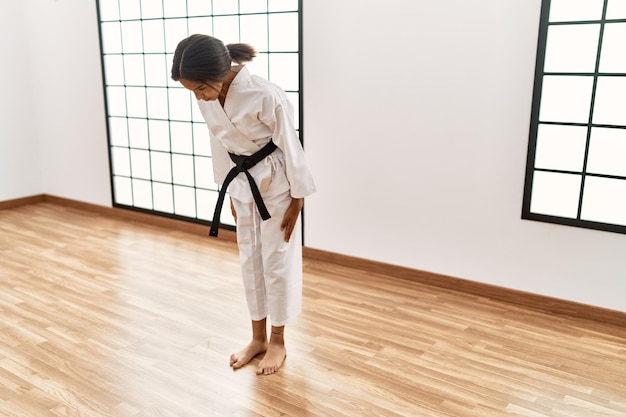 Zdjęcie afroamerykanka ubrana w kimono trenuje karate w centrum sportowym