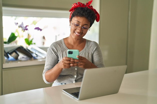 Afroamerykanka używająca laptopa i smartfona w domu