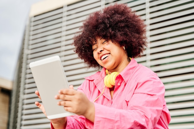 Afroamerykanka z kręconymi włosami przeprowadza wideorozmowę za pomocą tabletu