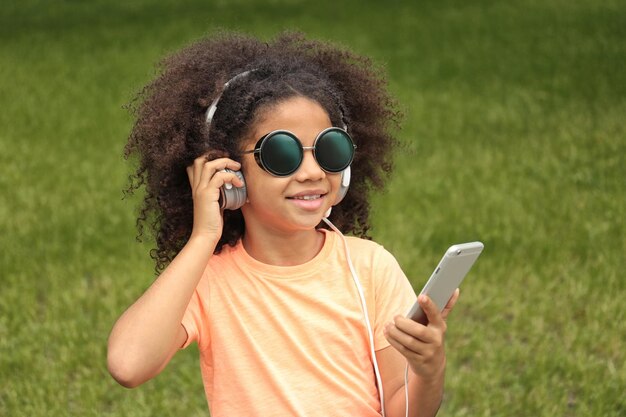 Afroamerykańska Mała Dziewczynka Słucha Muzyka W Parku W Okularach Przeciwsłonecznych