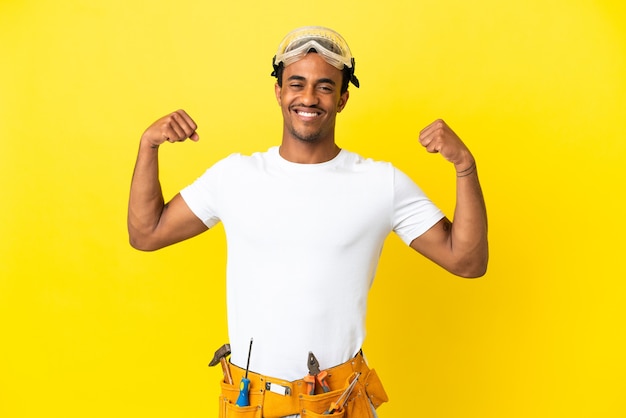 Afroamerykański elektryk mężczyzna nad odosobnioną żółtą ścianą robi silny gest