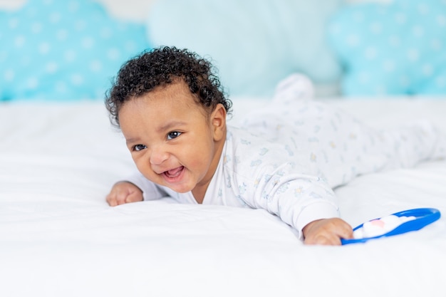 Afroamerykańskie małe dziecko uśmiecha się lub śmieje w łóżeczku