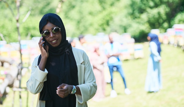 afrykańska kobieta biznesu korzystająca ze smartfona ubrana w tradycyjne islamskie ubrania