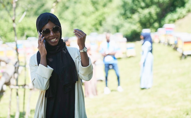 afrykańska kobieta biznesu korzystająca ze smartfona ubrana w tradycyjne islamskie ubrania