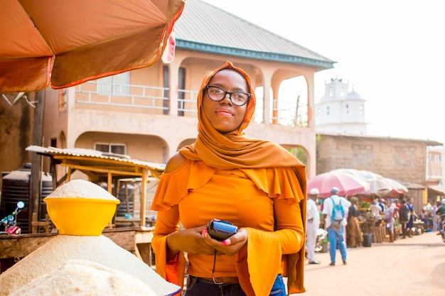 Afrykańska kobieta robi zakupy na lokalnym targu z automatem do sprzedaży