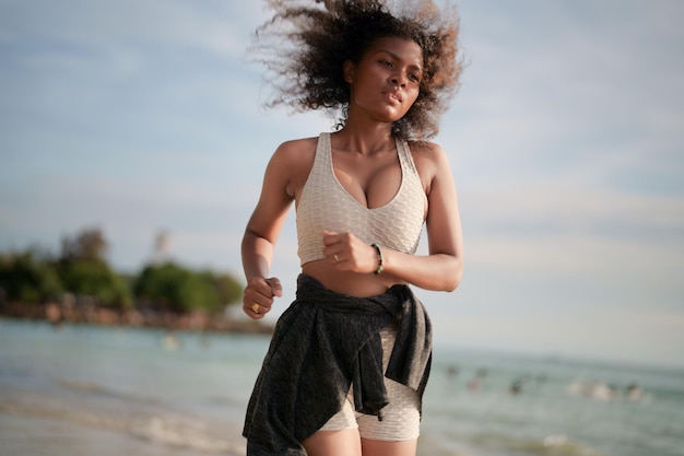 Afrykańska Kobieta W Staniku Sportowym Biega Na Plaży Do ćwiczeń Na świeżym Powietrzu Portret Sexy Dama Afrykańskich Azjatyckich Przygotowuje Się Do Przydatności Na Plaży