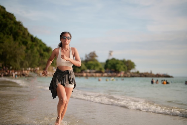 Afrykańska kobieta w staniku sportowym biega na plaży do ćwiczeń na świeżym powietrzu Portret sexy dama afrykańskich azjatyckich przygotowuje się do przydatności na plaży