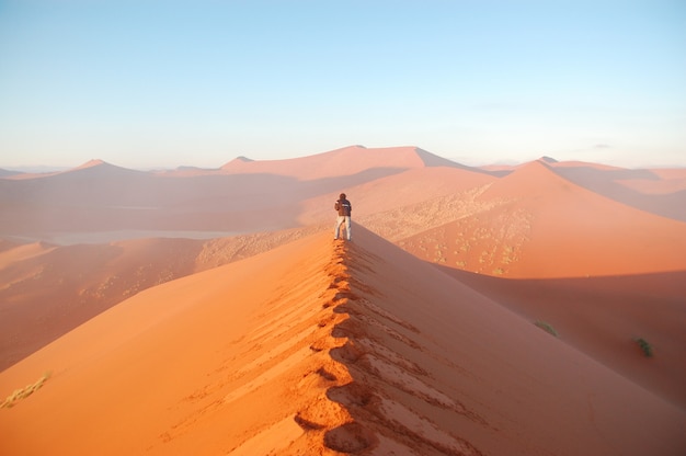 Afrykańska przygoda na pustyni. Fotograf robi zdjęcia wschód słońca wydm pustyni Namib. Namibia, Republika Południowej Afryki