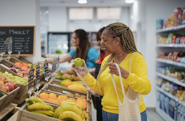 Afrykańska starsza kobieta kupująca świeże organiczne owoce na lokalnym mini marketie