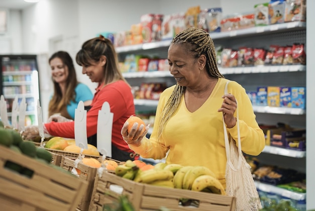 Afrykańska starsza kobieta kupuje świeże organiczne owoce w supermarkecie