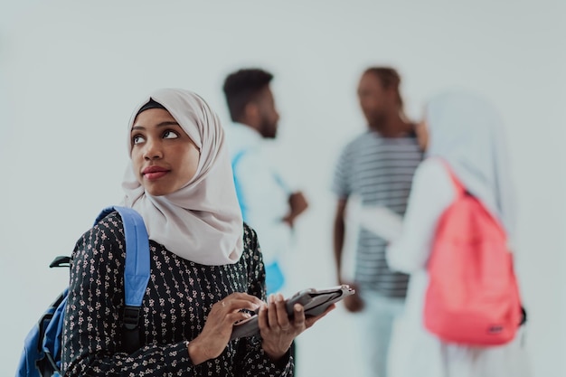 Afrykańska Studentka Z Grupą Przyjaciół W Tle, Ubrana W Tradycyjny Islamski Hidżab. Selektywne Skupienie. Zdjęcie Wysokiej Jakości