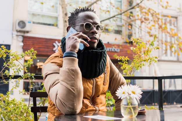 Afrykański dorosły człowiek na zewnątrz rozmawia przez telefon koncepcja technologii przestrzeni kopii